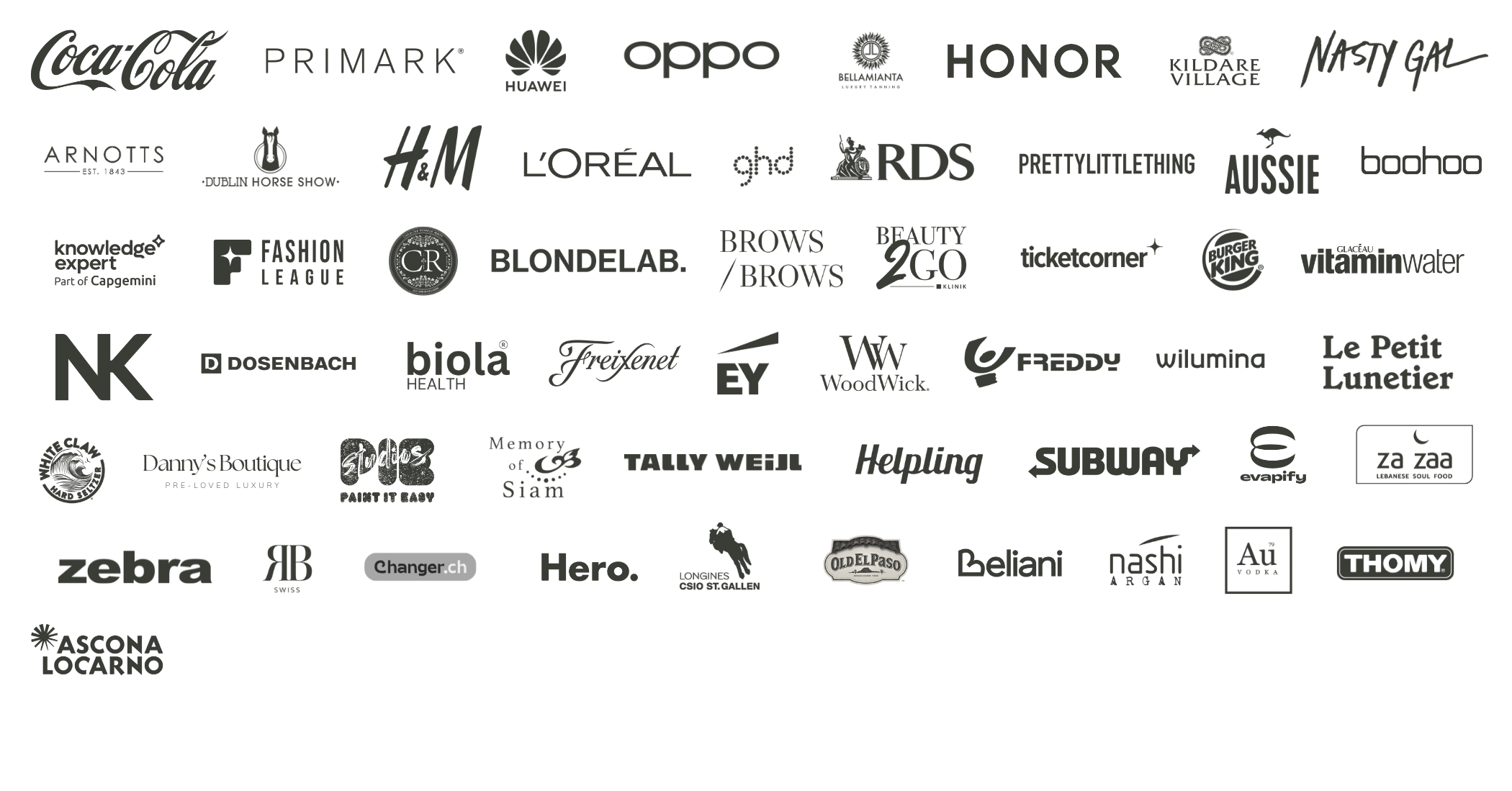 Collection of various brand logos displayed in black and white, including Coca-Cola, Primark, Huawei, Oppo, Bellamanta, Honor, Kildare Village, Misty Gal, Arnotts, Dublin Horse Show, H&M, L'Oreal, ghd, RDS, PrettyLittleThing, Aussie, Boohoo, Knowledge Expert, Fashion League, CK, BlondeLab, Brows Brows, Beauty 2Go, Ticketcorner, KFC, Vitaminwater, NK, Dosenbach, Biola Health, Frejent, EY, WoodWick, Freddy, Wilmina, Le Petit Lunetier, Danny's Boutique, P.O.P, Memory of Siam, Tally Wajid, Helping, Subway, Uber, Za Zaa, Zebra, AB Swiss, Changer.ch, Hero., Longines, Old El Paso, Beliani, Nashi Argan, Au Vodka, Thomy, Ascona Locarno.