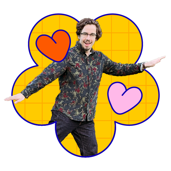 A man with glasses and curly hair smiling with arms outstretched, standing in front of a graphic background with a blue and yellow grid, and three colorful heart illustrations in red, pink, and purple.