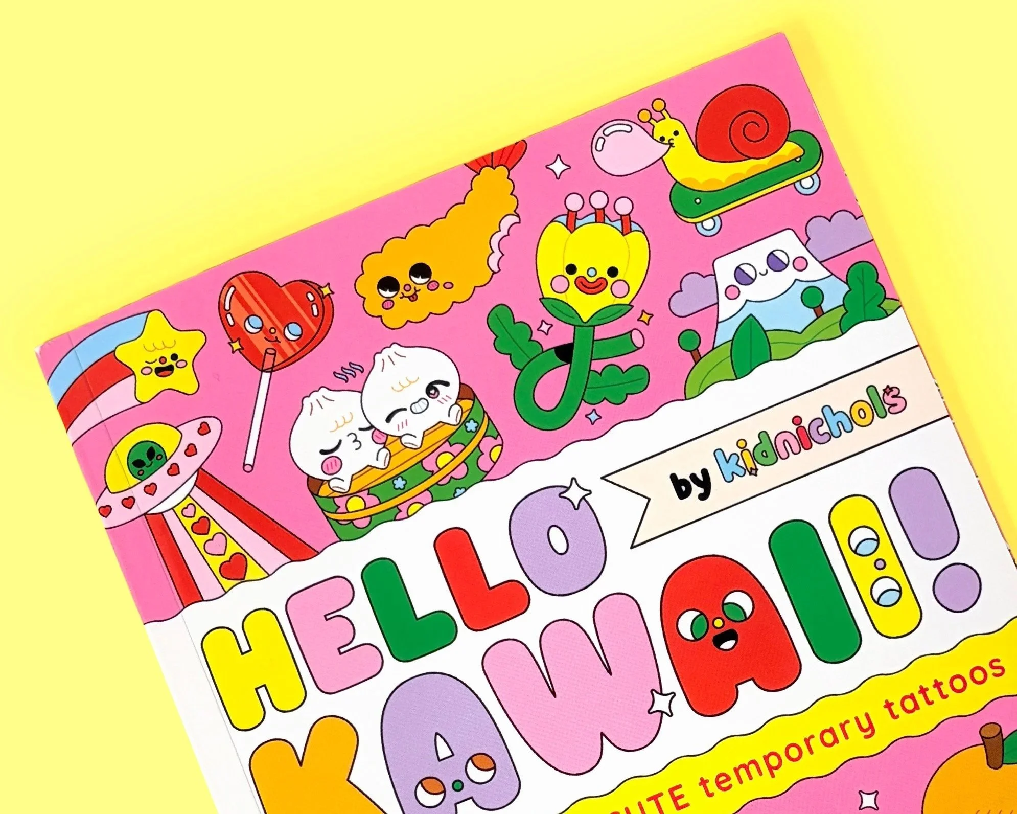 Colorful children's activity book cover featuring cartoon animals on a pink background, with a yellow star and rainbow design, and a yellow banner with multicolored text.