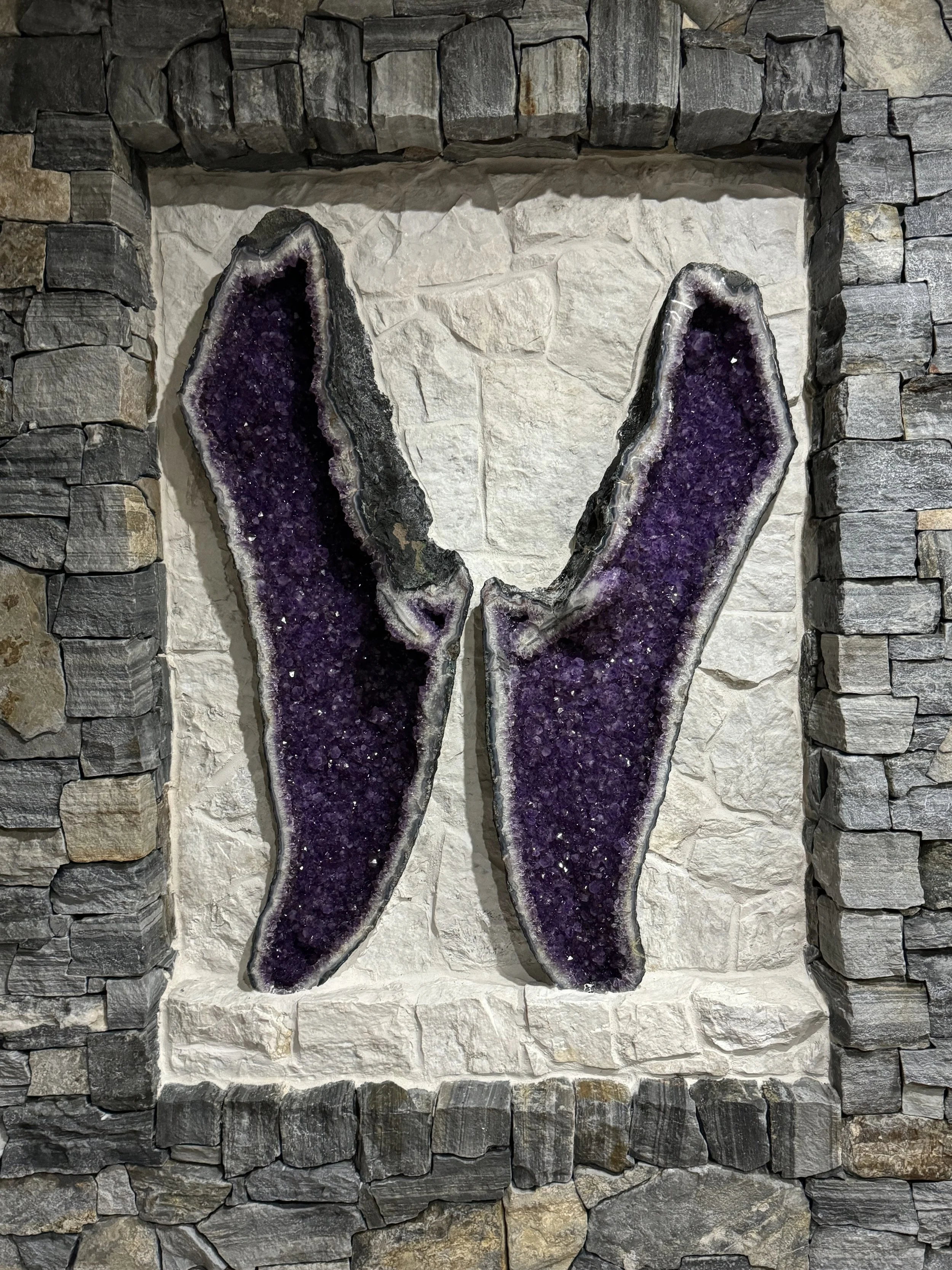 Decorative purple geode slices mounted on a stone wall.
