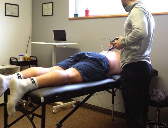 athlete performing strength training exercise on turf in a physical therapy facility