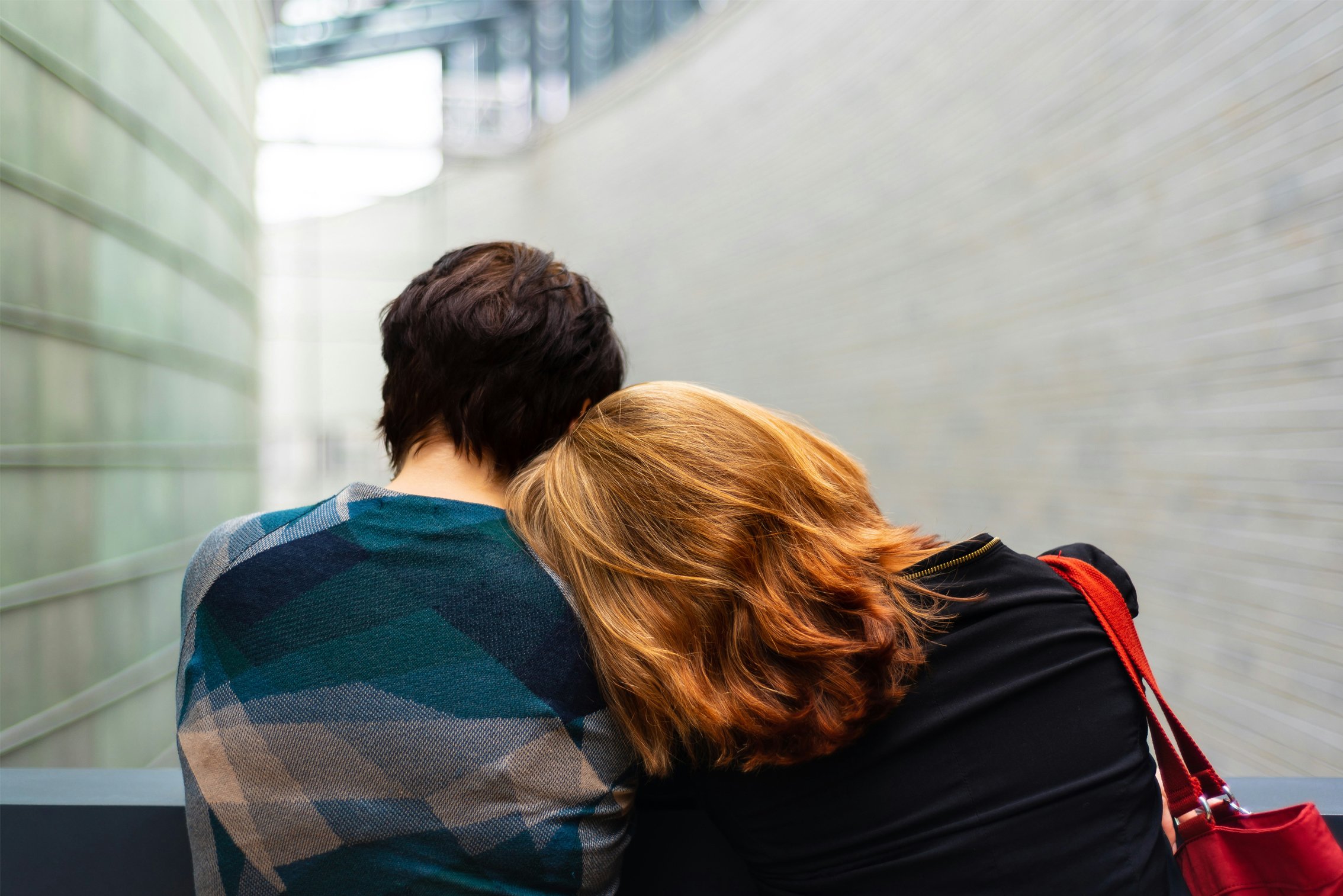 A woman rests her head on another woman's shoulder
