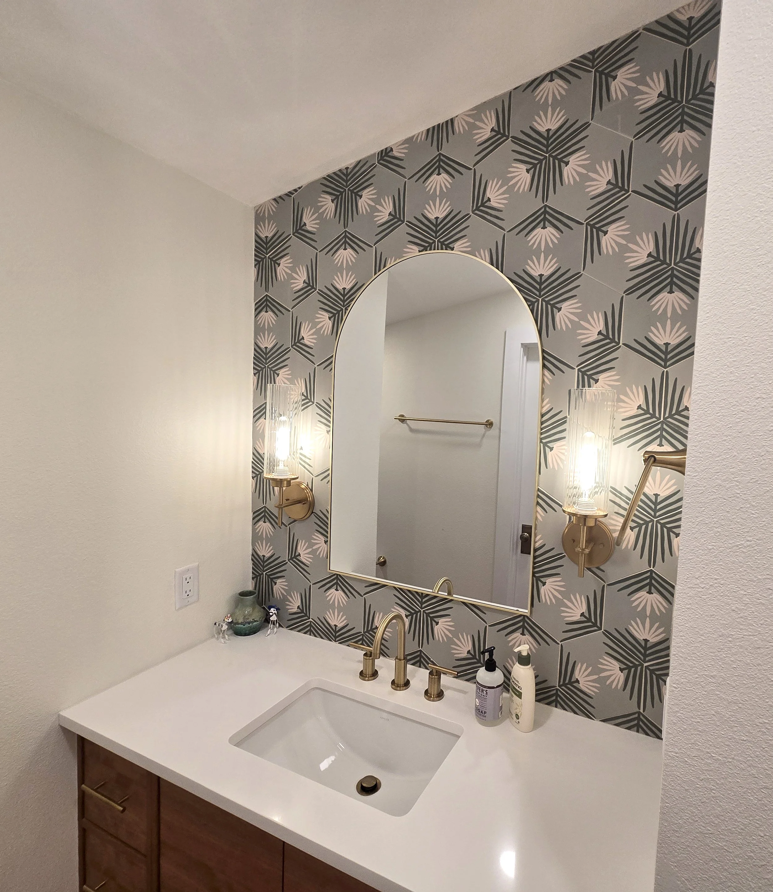 Warm tile and wood colors balance the crisp white countertops in the guest bath
