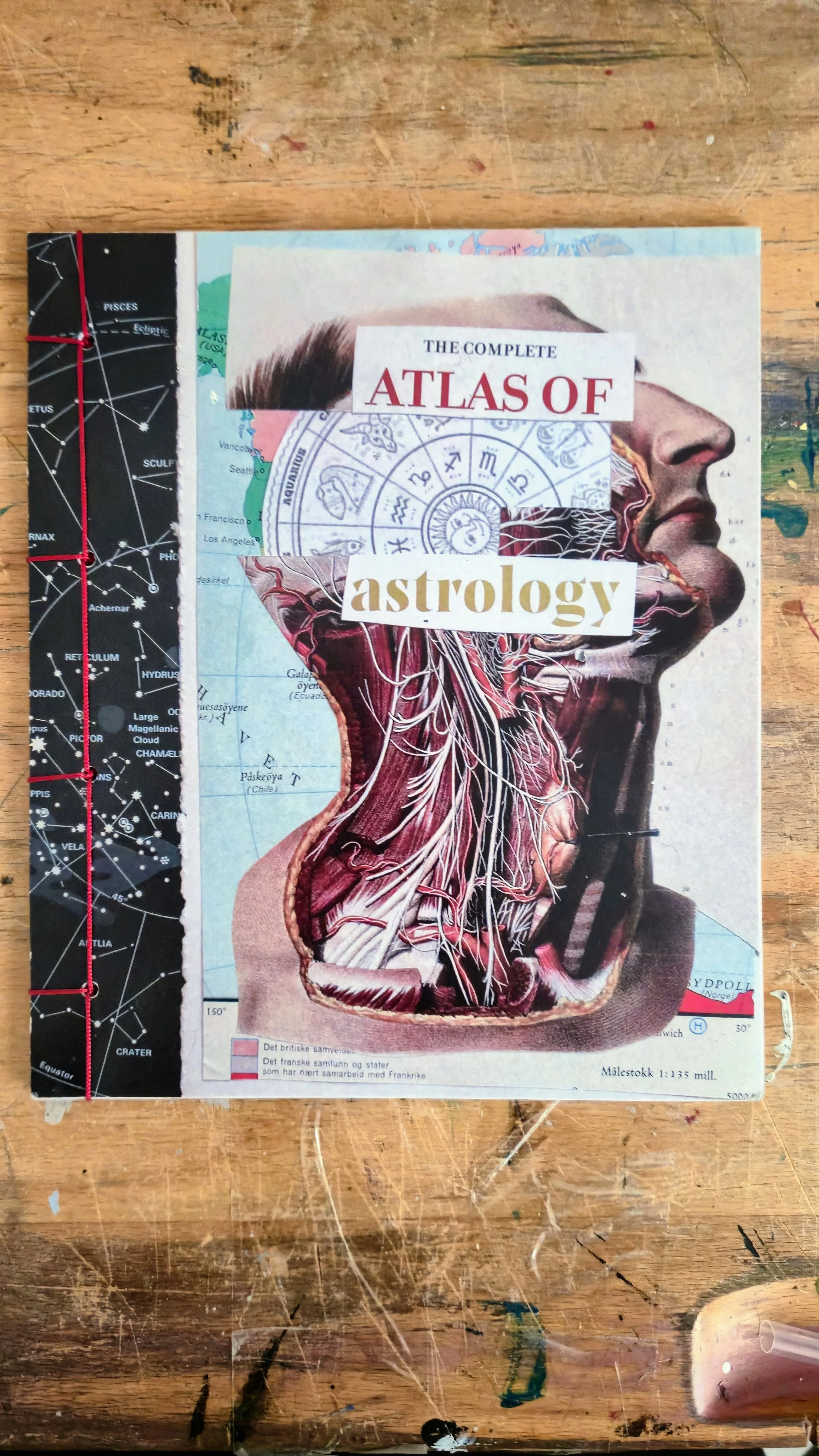 Cover of a book titled 'The Complete Atlas of Astrology' featuring a human profile with an anatomical illustration of the head and neck on an astronomical and map background, lying on a wooden surface.