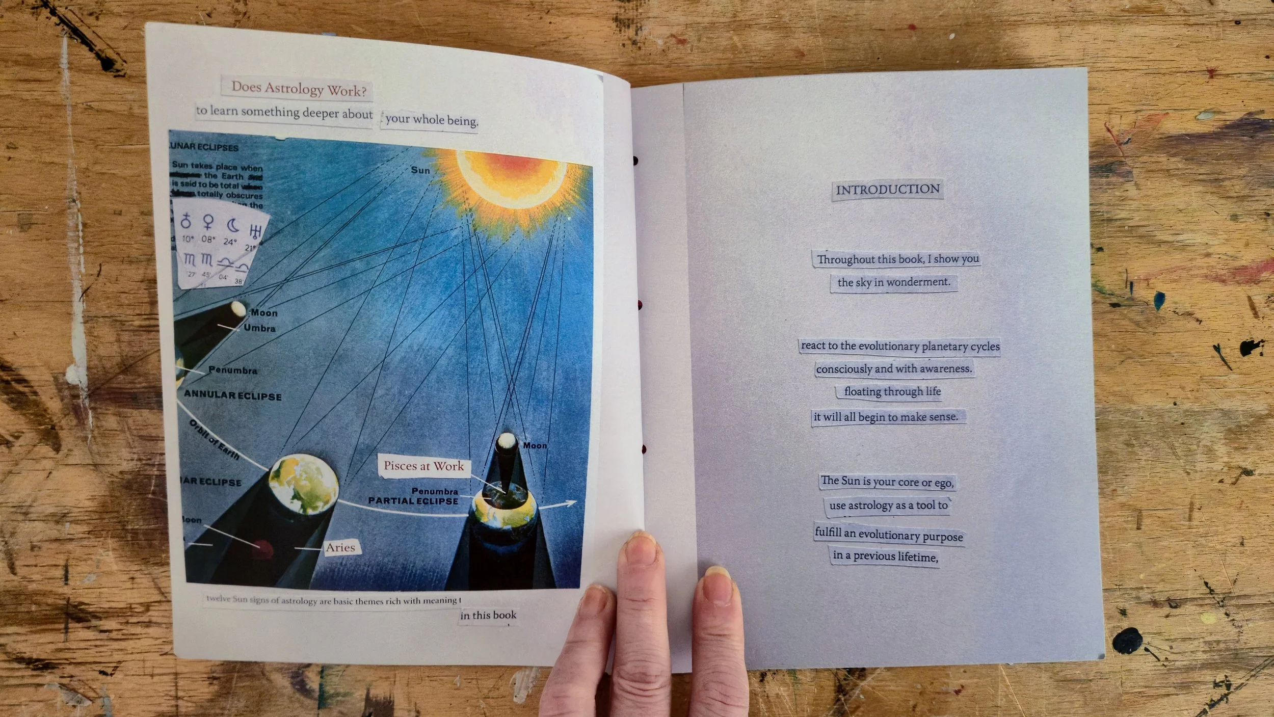 Open booklet with text and illustration about astrology, featuring a diagram of the sun, moon, and eclipse cycles on a wooden surface.