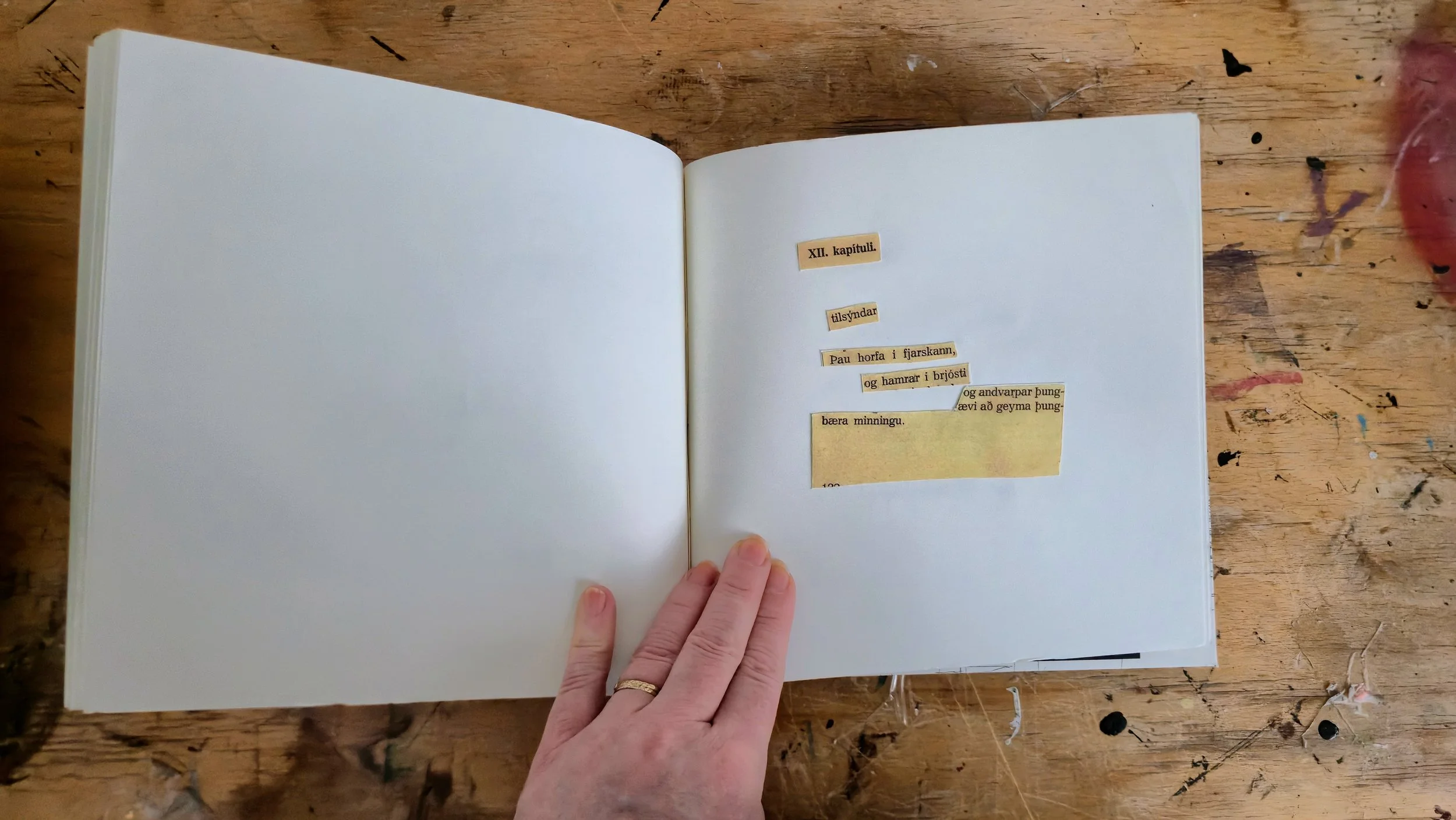 An open book on a wooden table with a collage of Viking-related phrases in Icelandic.