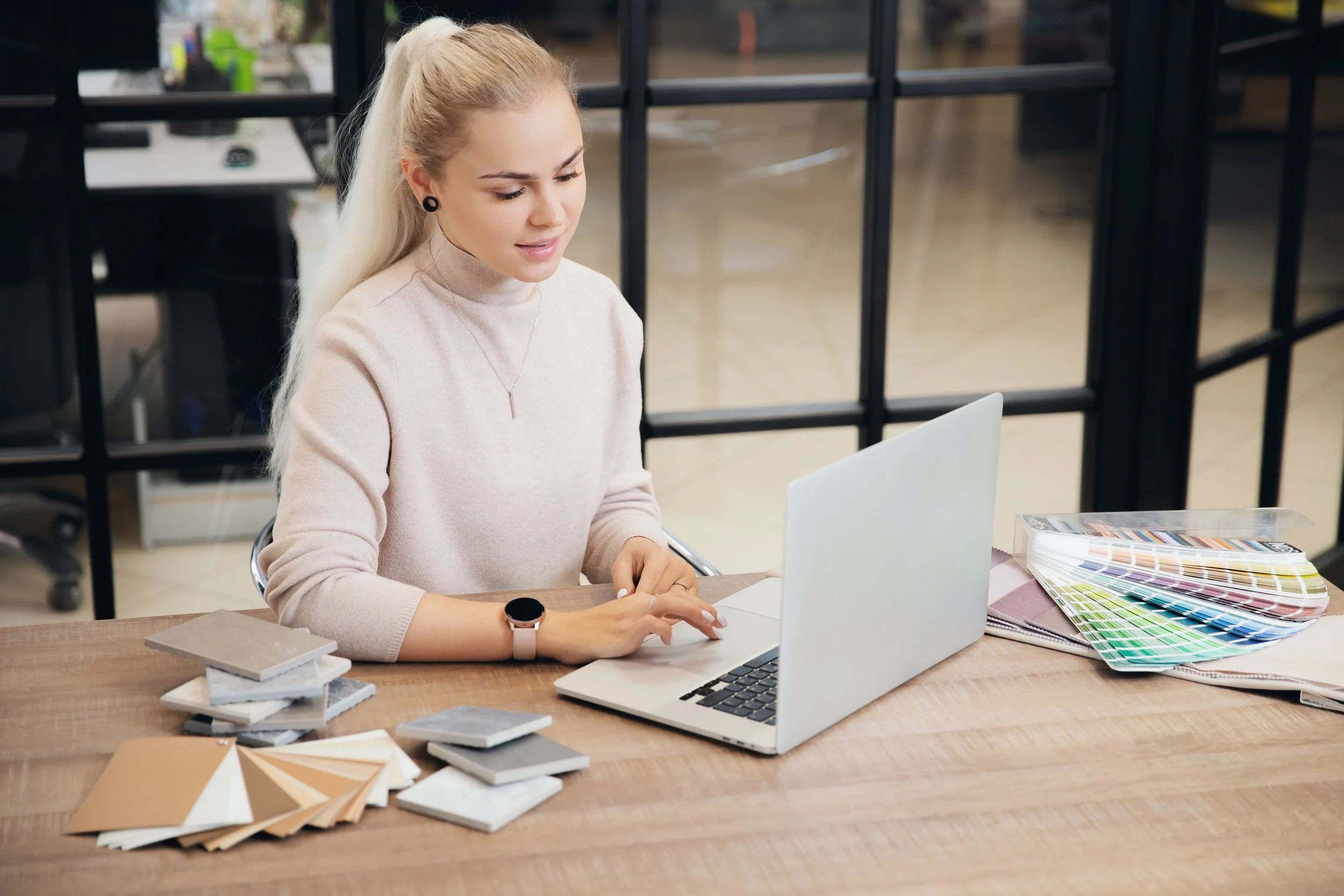 A Kitchen and Bath Creations designer working with color sample swatches, and and reviewing options with a client online.