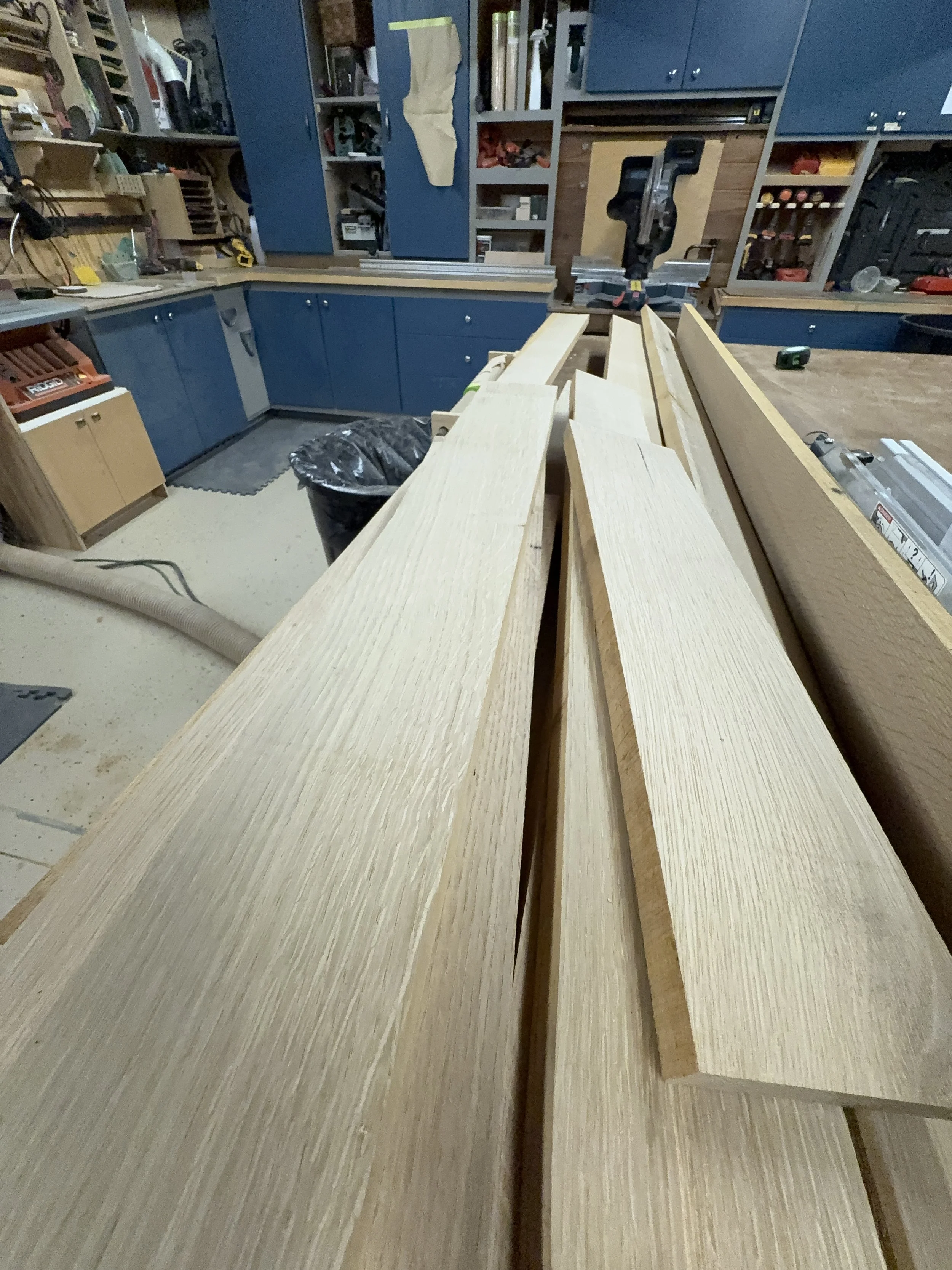 White oak boards stacked in shop during closet cabinetry build