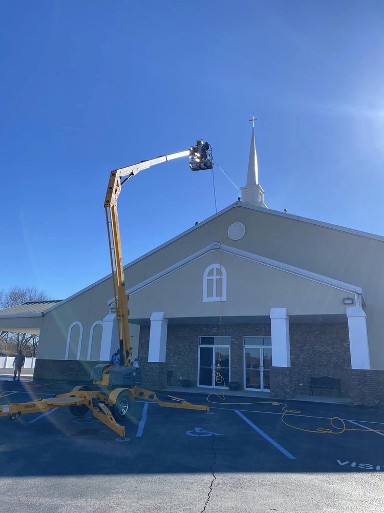 Soft washing a church roof with a boom lift