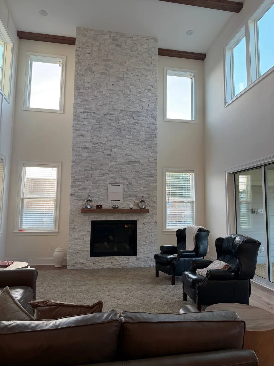 Two-story stone fireplace with wood mantel and exposed beams, Raleigh NC