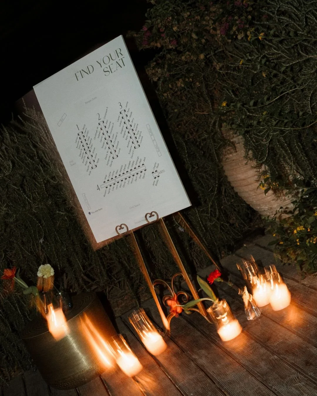 A seating chart in Crete wedding reception illuminated by candlelight.