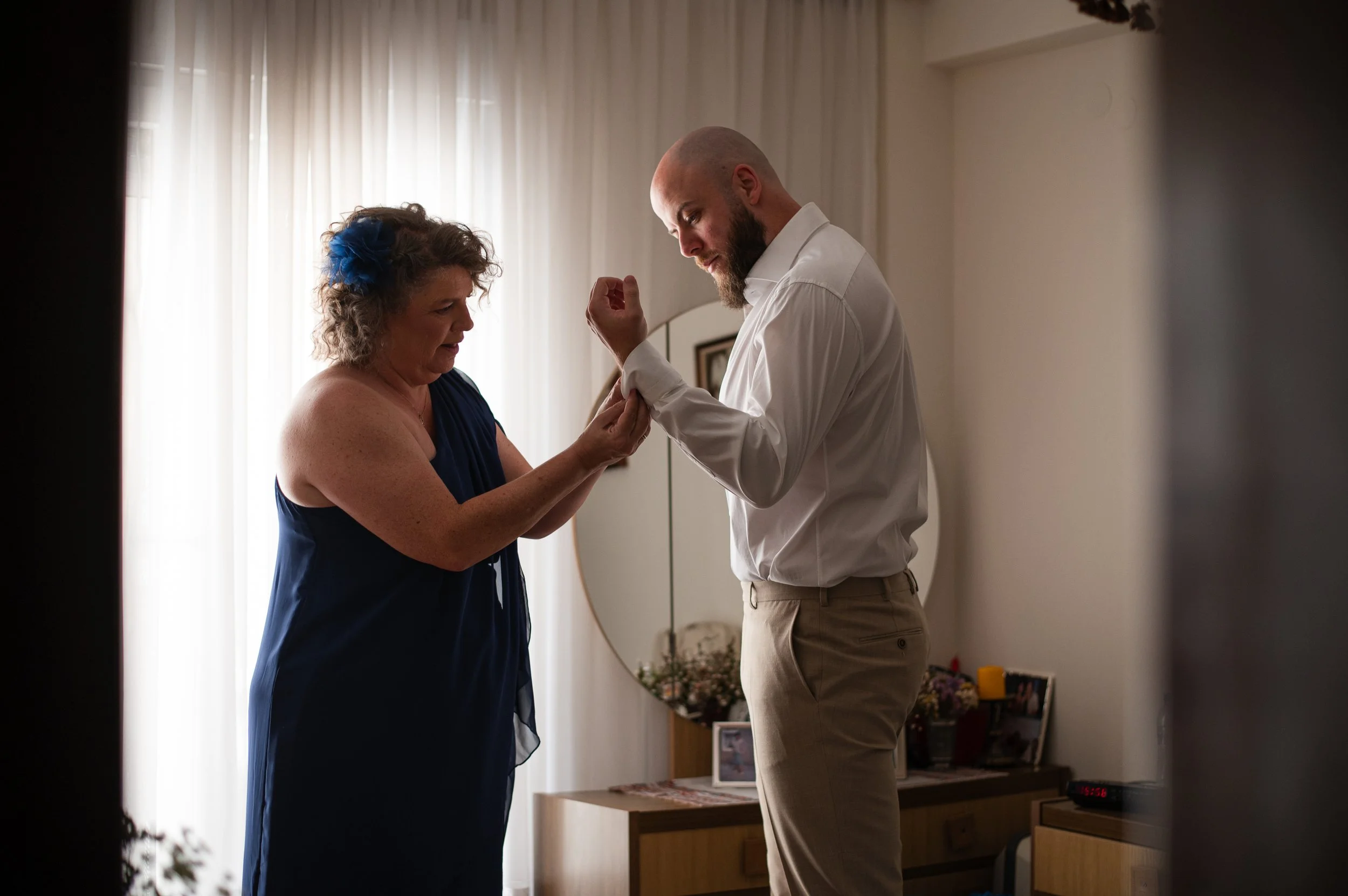 Groom getting ready with friends during a Greek wedding celebration