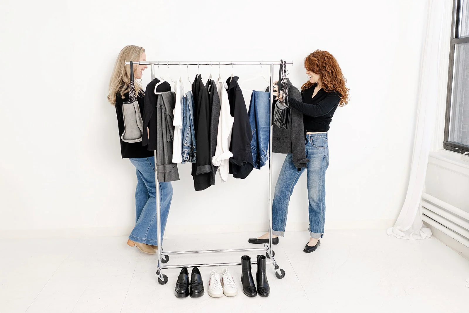 Four black rolled-up yoga mats inside a wooden basket.