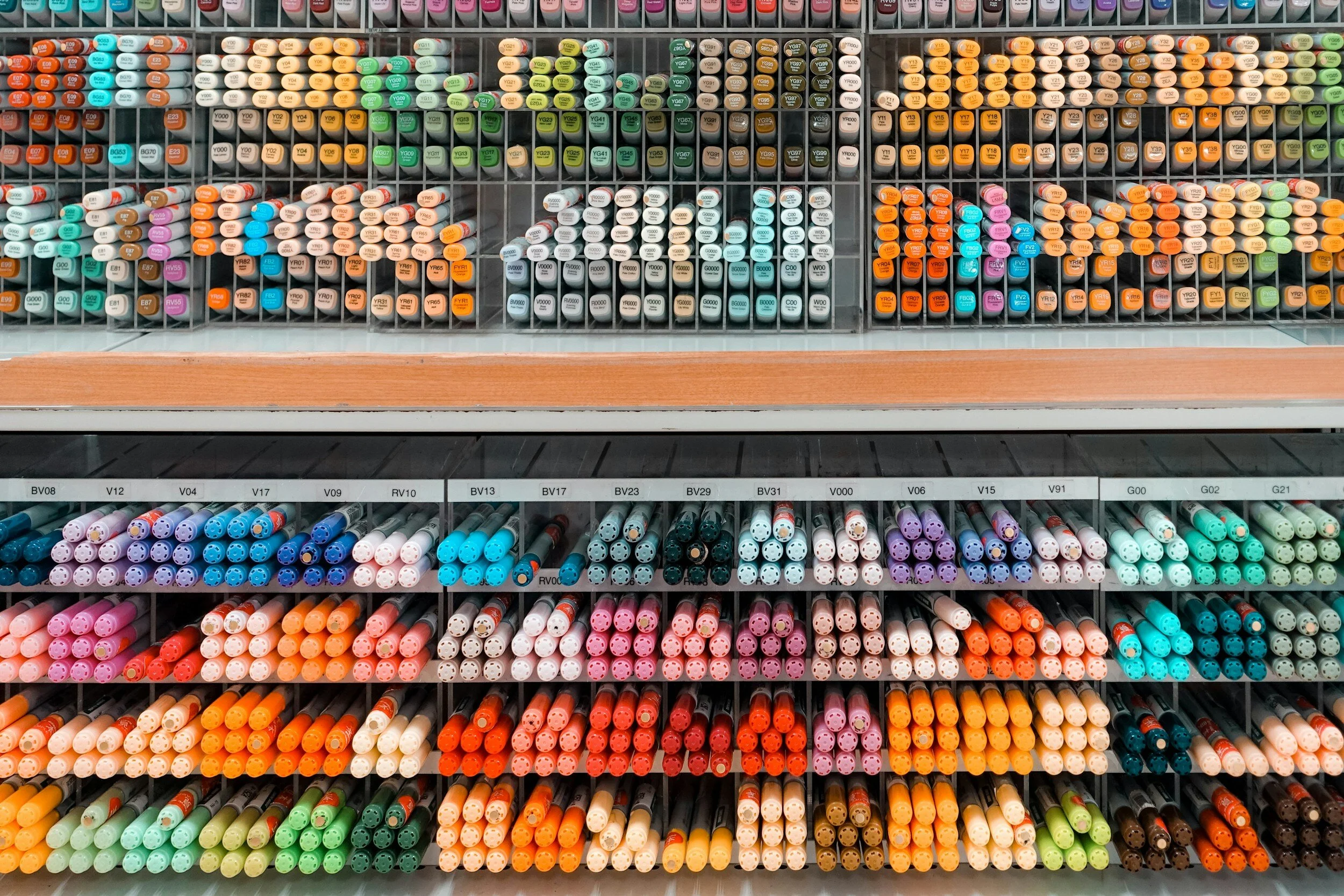 A display of colorful markers organized in rows on shelves in a store.