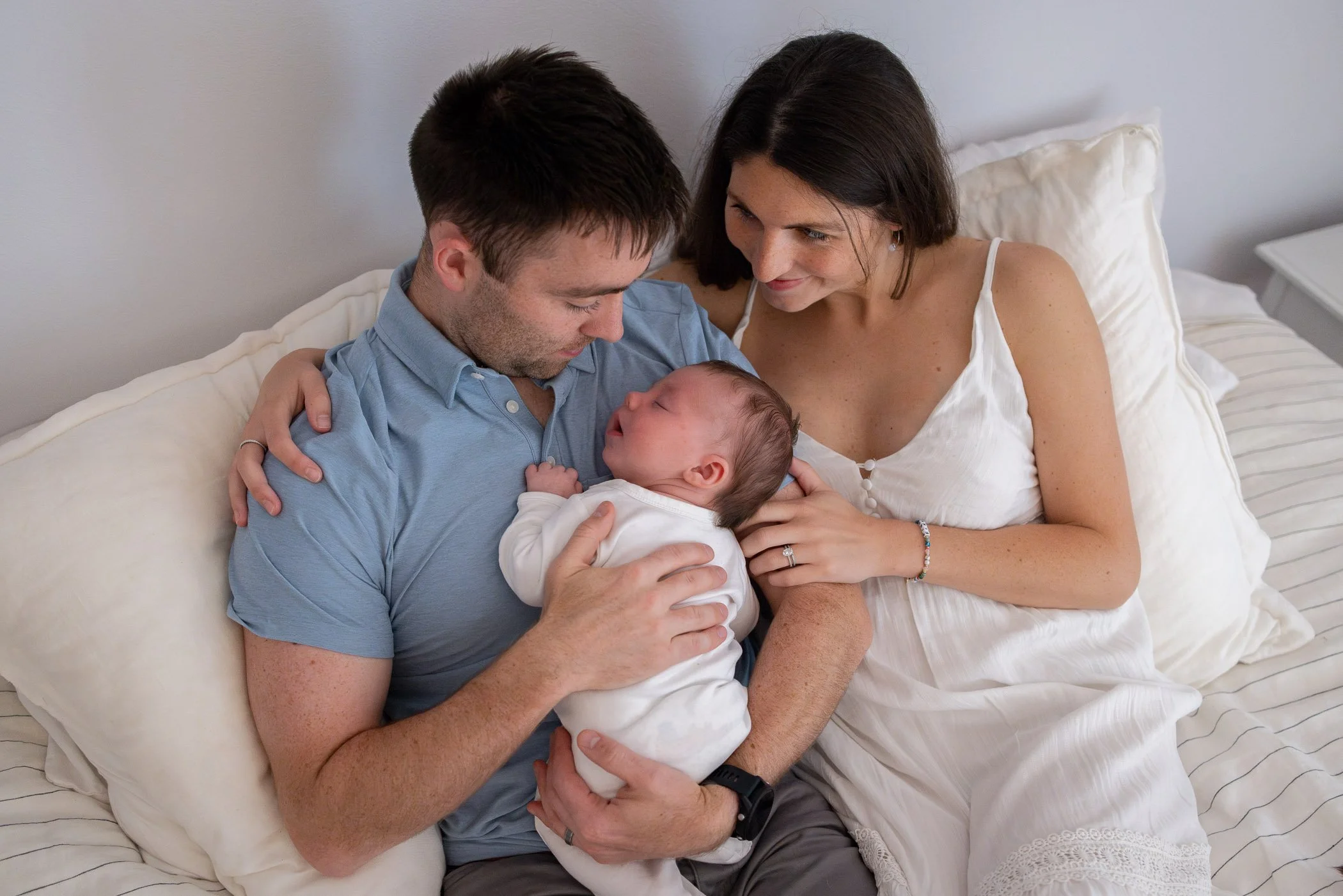 Family cuddle during newborn photo session on the South Shore
