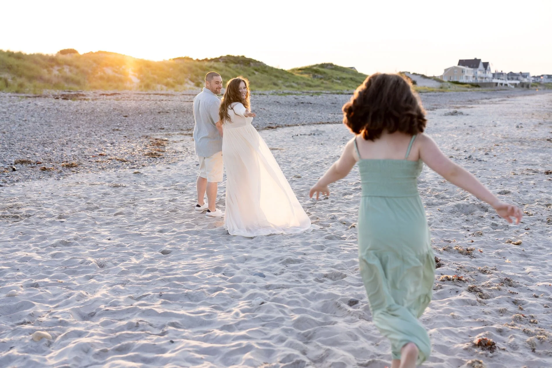 mom-reaching-back-to-daughter-running-in-sand-at-sunset.jpg