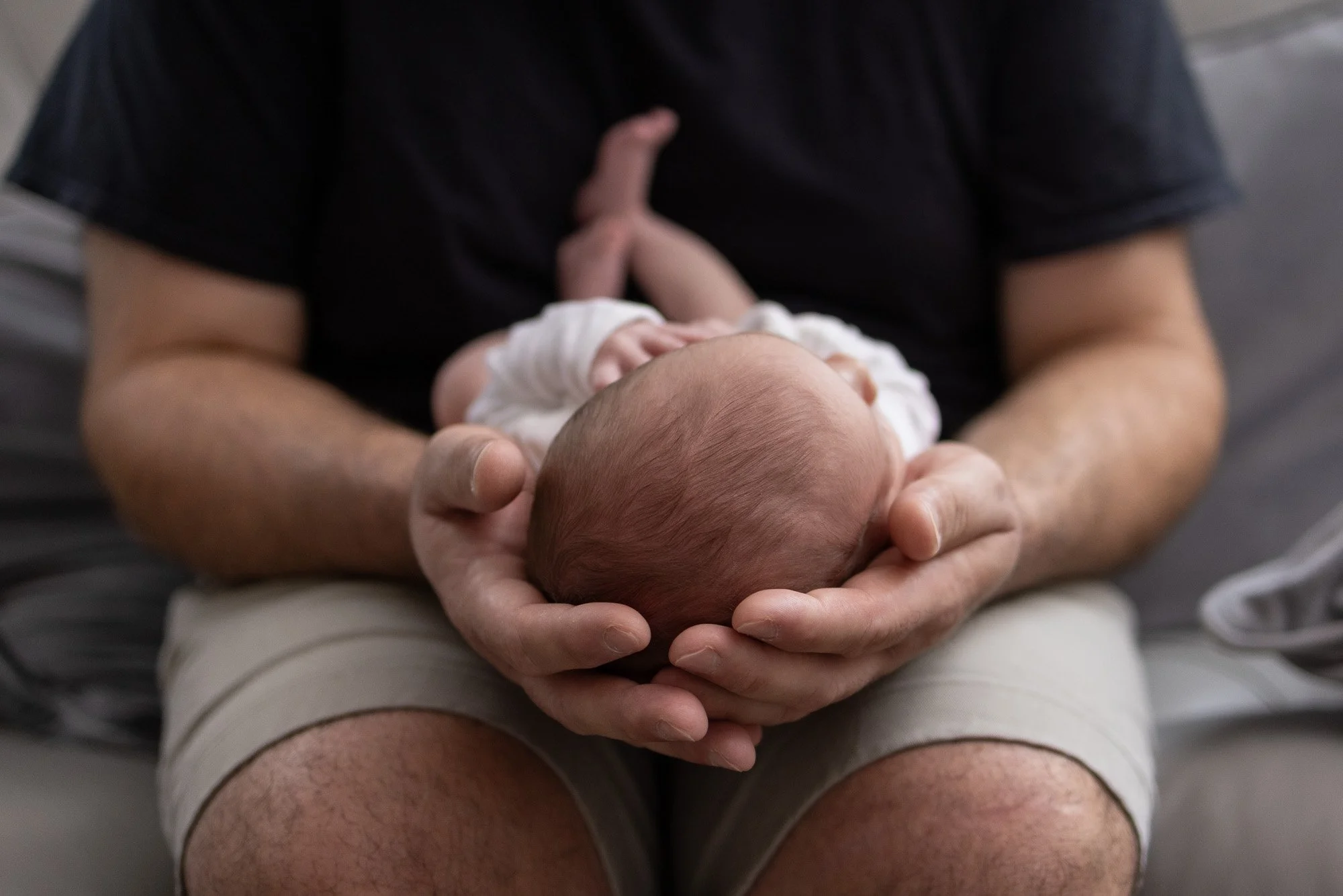 dad holding newborn daughter in lap.jpg