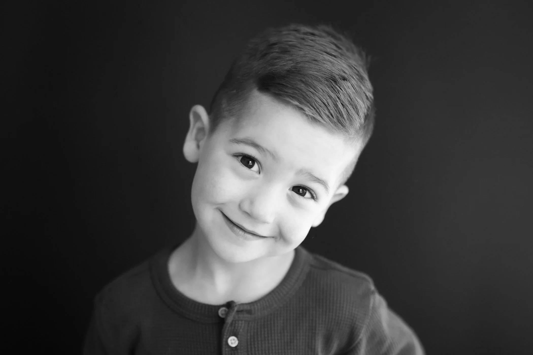 fine are school picture of young boy with head tilted and gentle smile