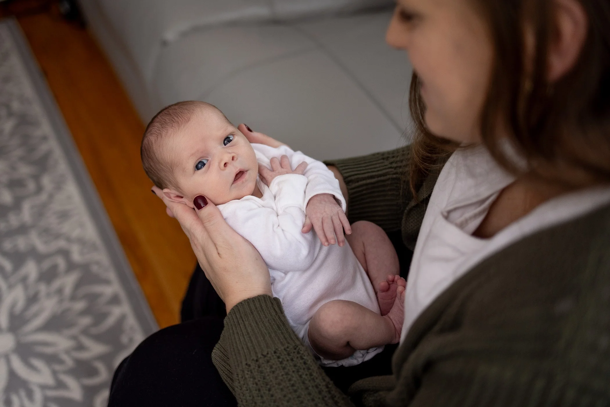 Mom cradles baby during newborn photos on the South Shore