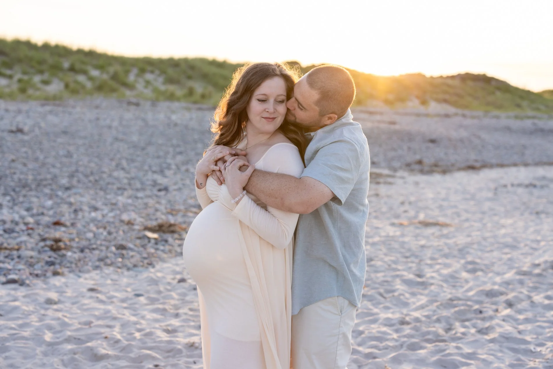 maternity-session-with-husband-kissing-wifes-cheek-at-sunset.jpg