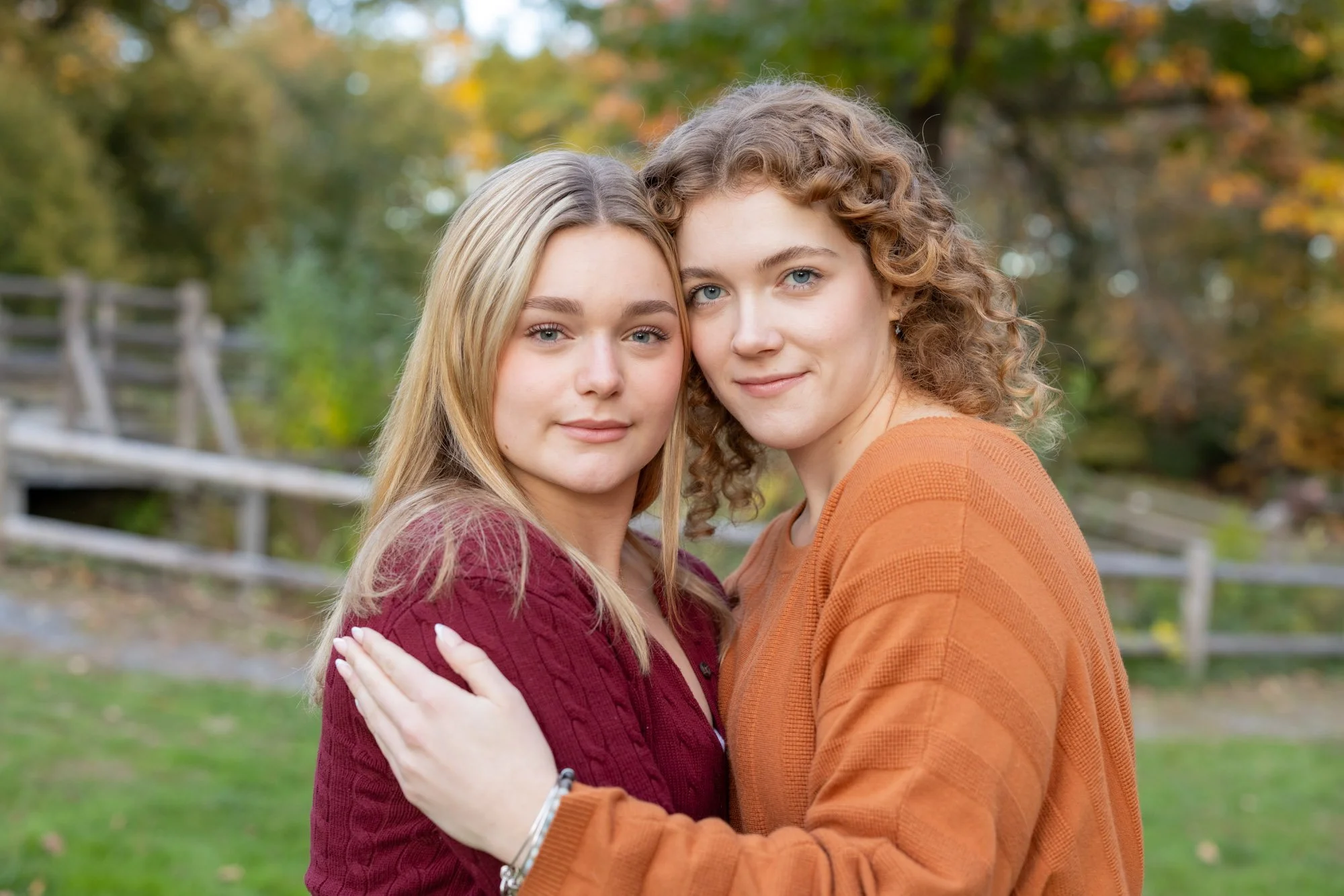 sisters hugging in park with fall colors.jpg