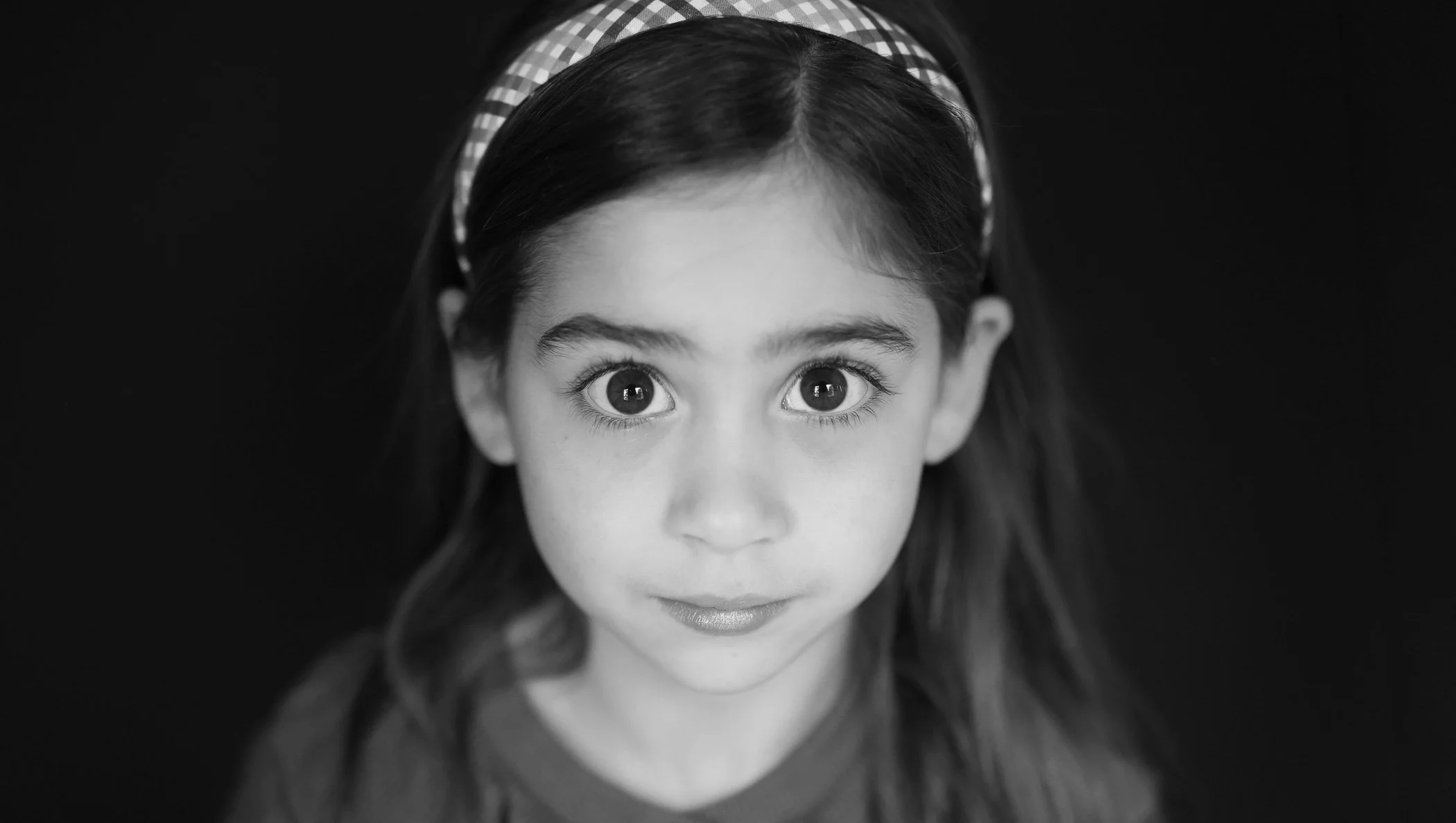 school photo headshot of young girl with black background