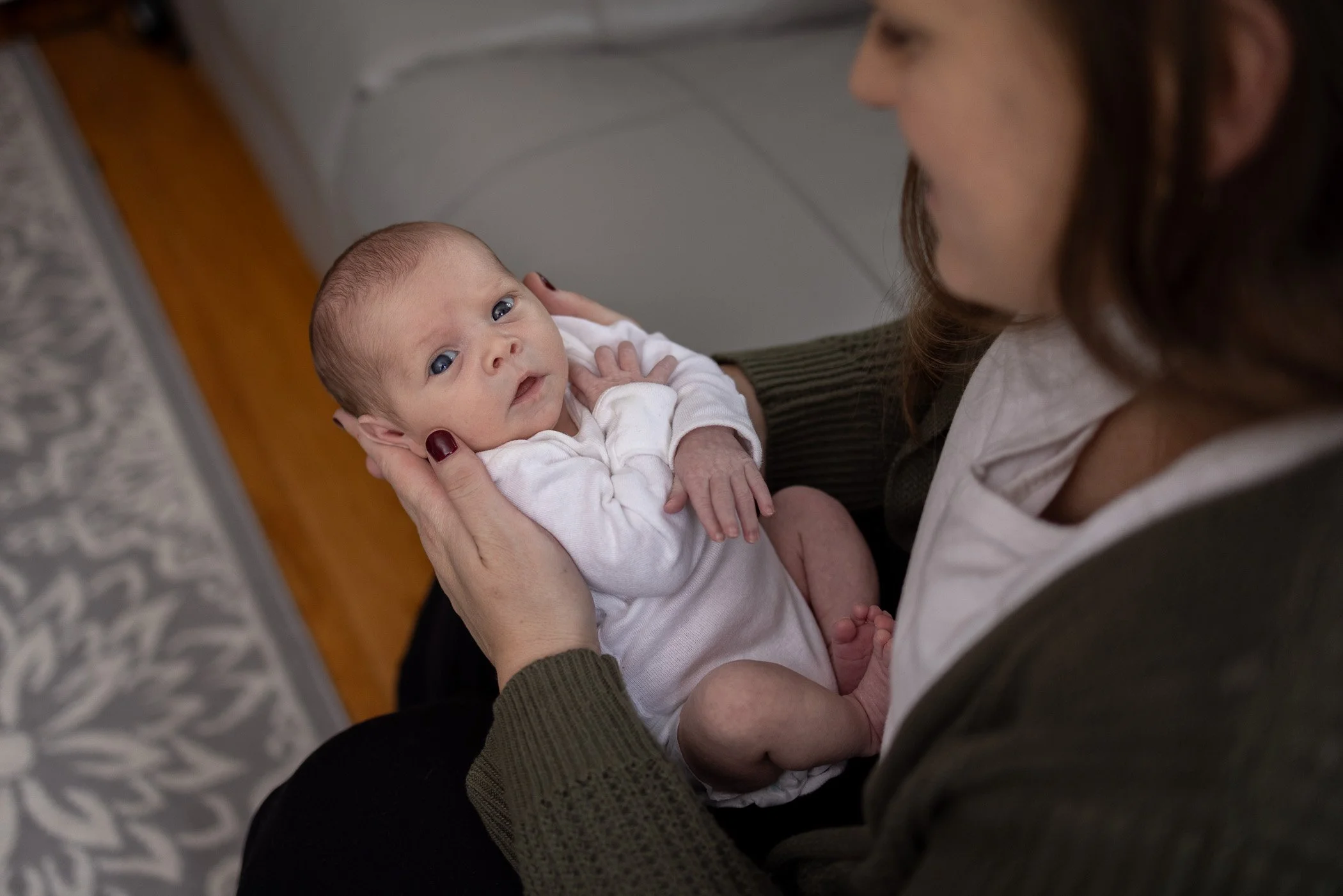 Mom cradles baby during newborn photos on the South Shore