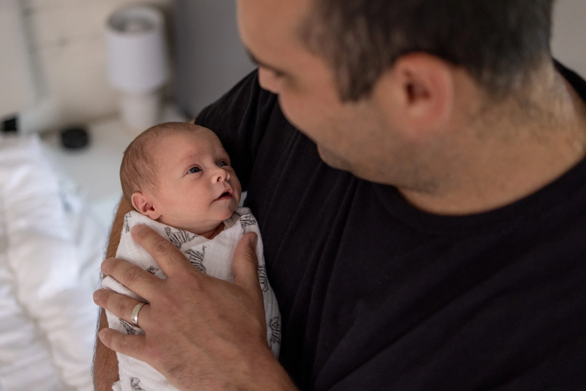 newborn baby and dad gazing at eachother showing love.jpg
