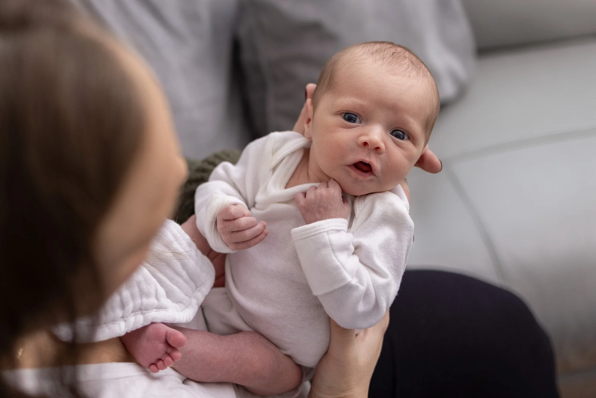 mom holding newborn girl on couch.jpg
