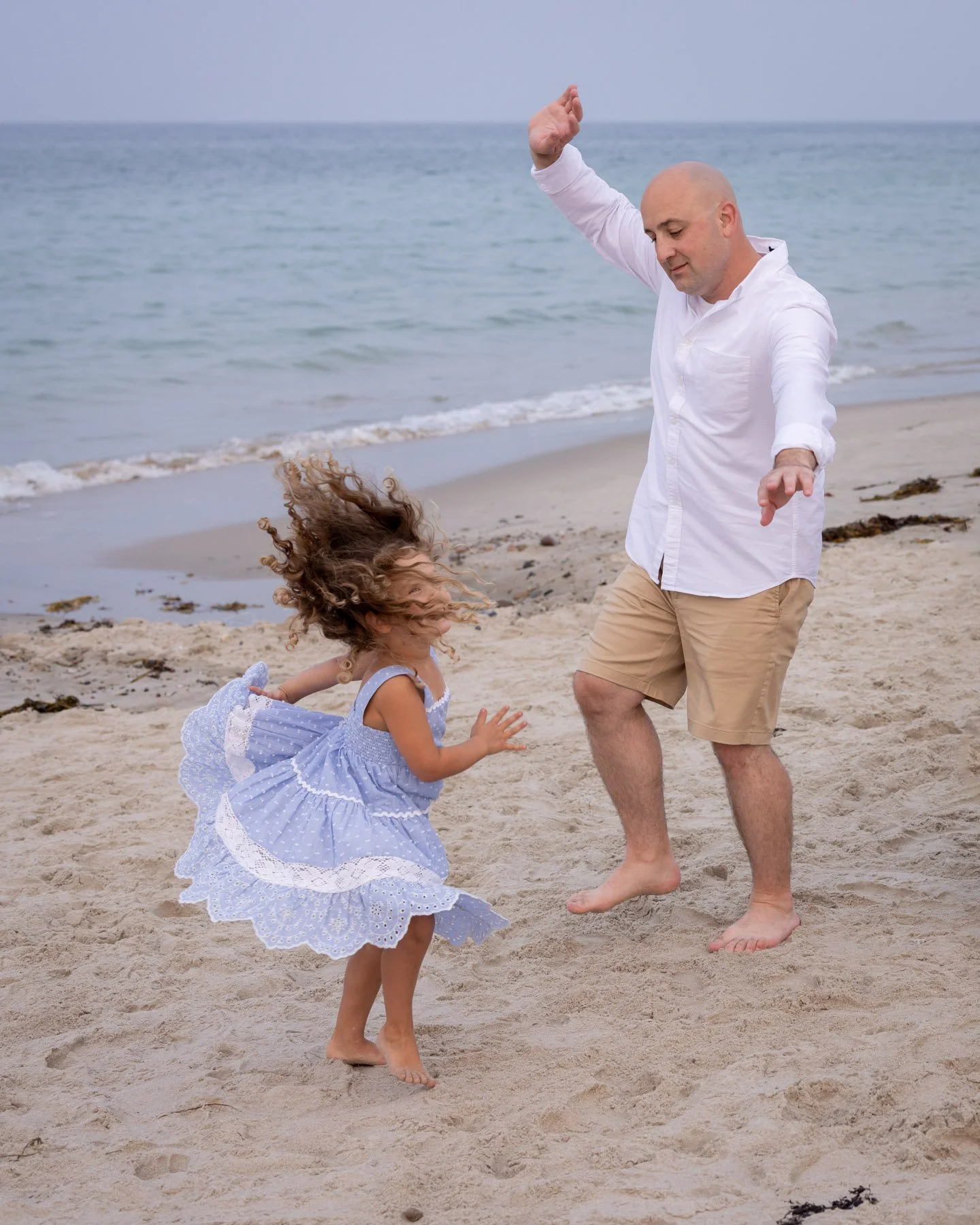 daugher and daddy dance barefoot on beach