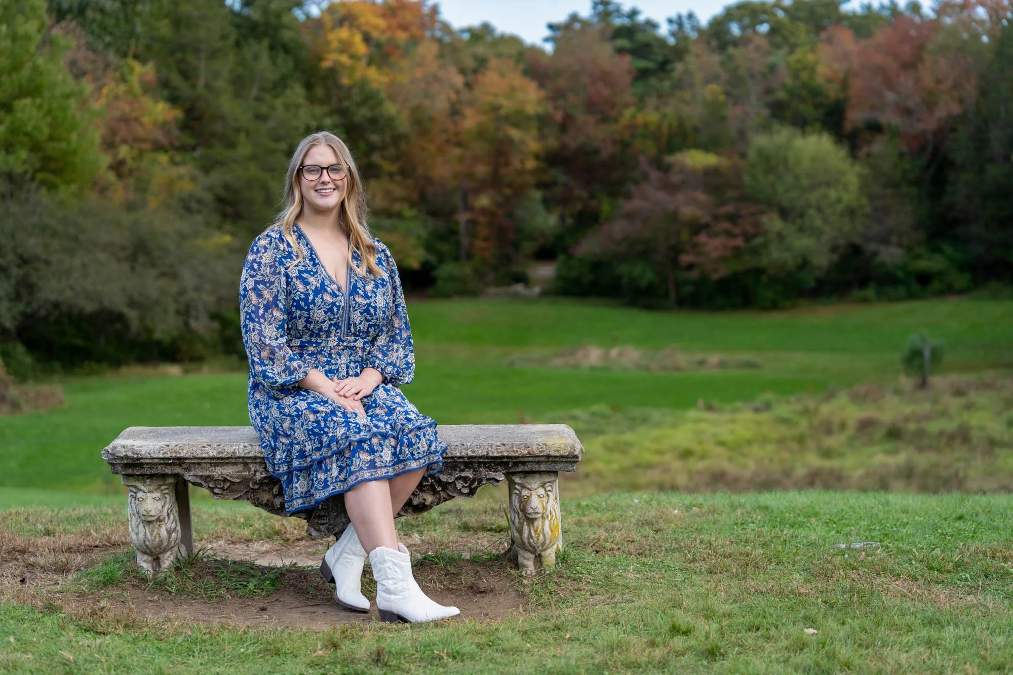 senior female sitting on stone bench wearing white boots