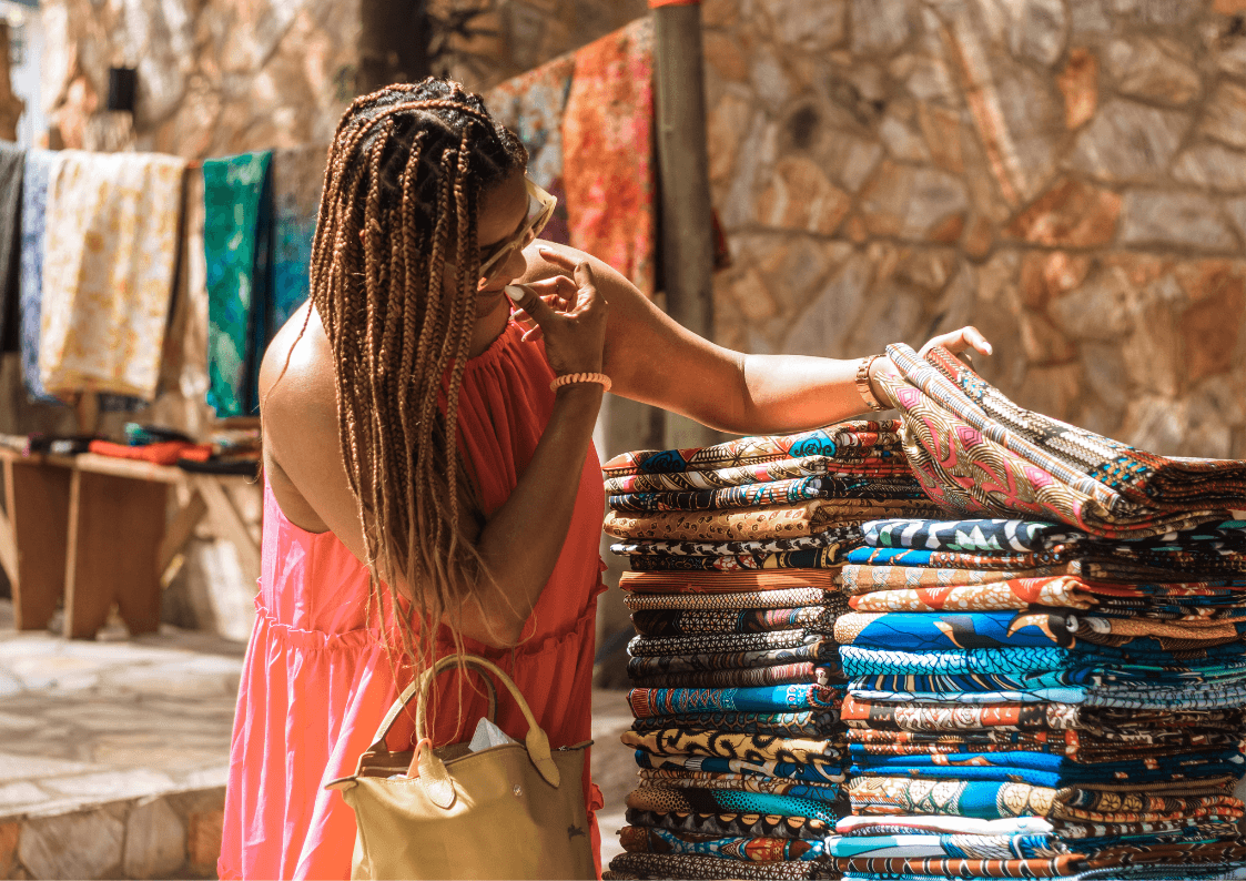 A lady looking through a stack of ankara fabric