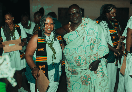 A diaspora traveler taking a photo with a chief in GHANA after a Ghanaian naming ceremony