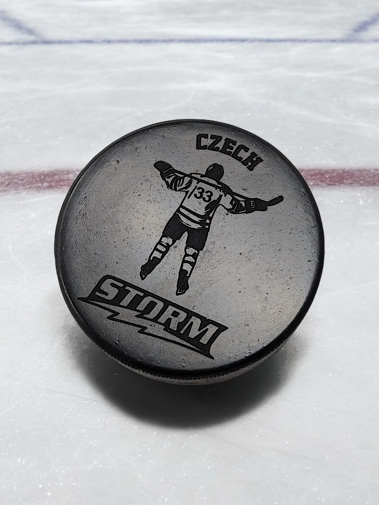 Hockey puck on ice with "Czech Storm" and a player graphic.