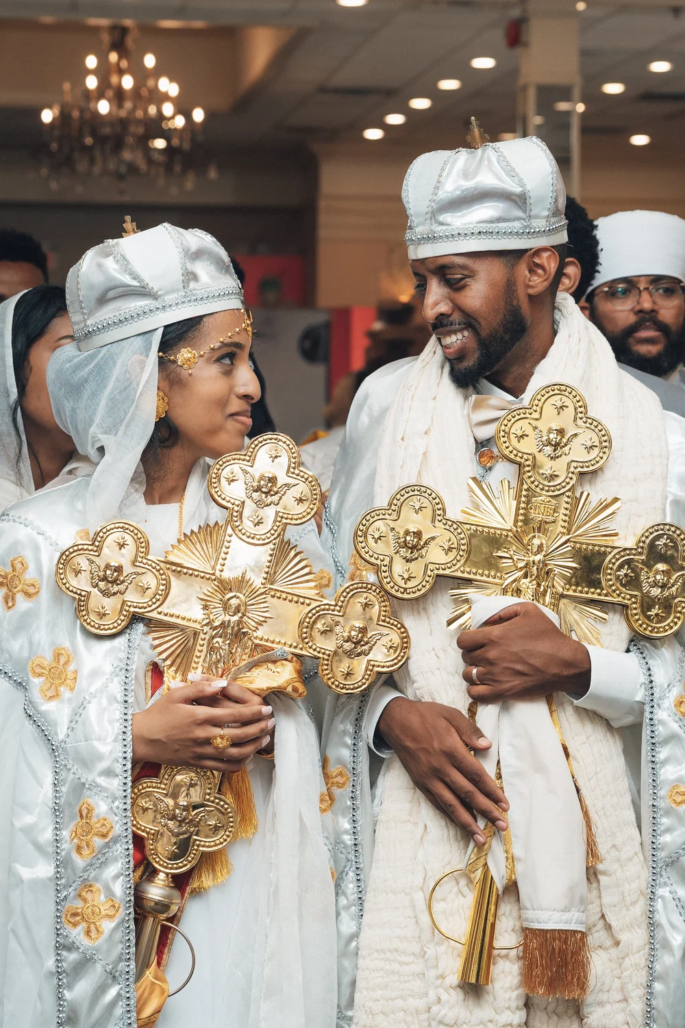 Couple in traditional attire with ornate gold crosses