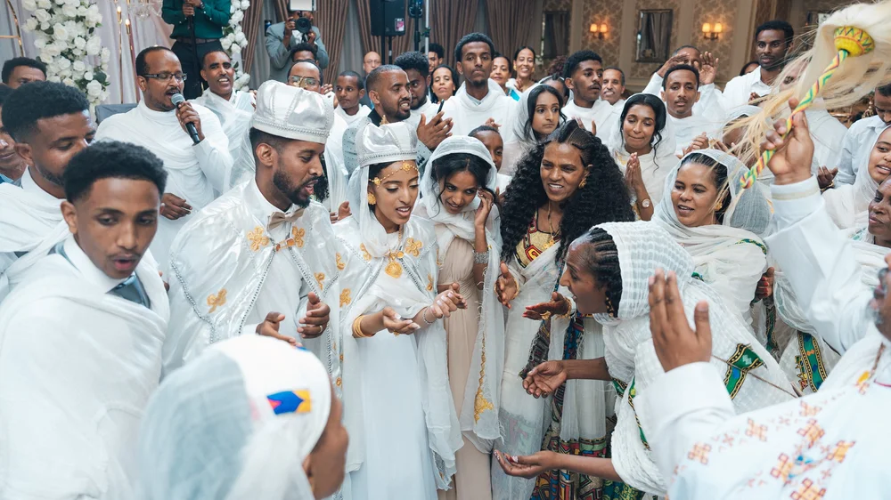 Guests in traditional white attire celebrating with the couple