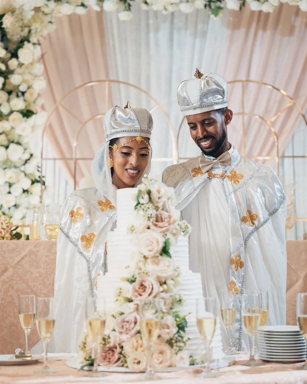 Couple behind a tiered wedding cake