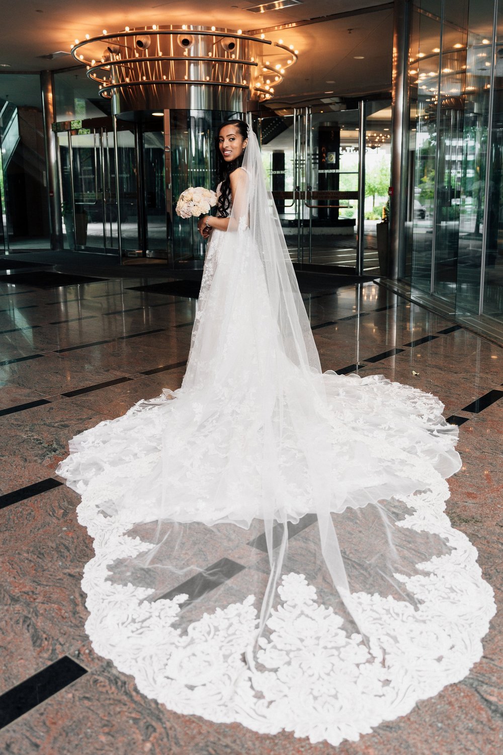 Bride in a lace veil in a modern lobby