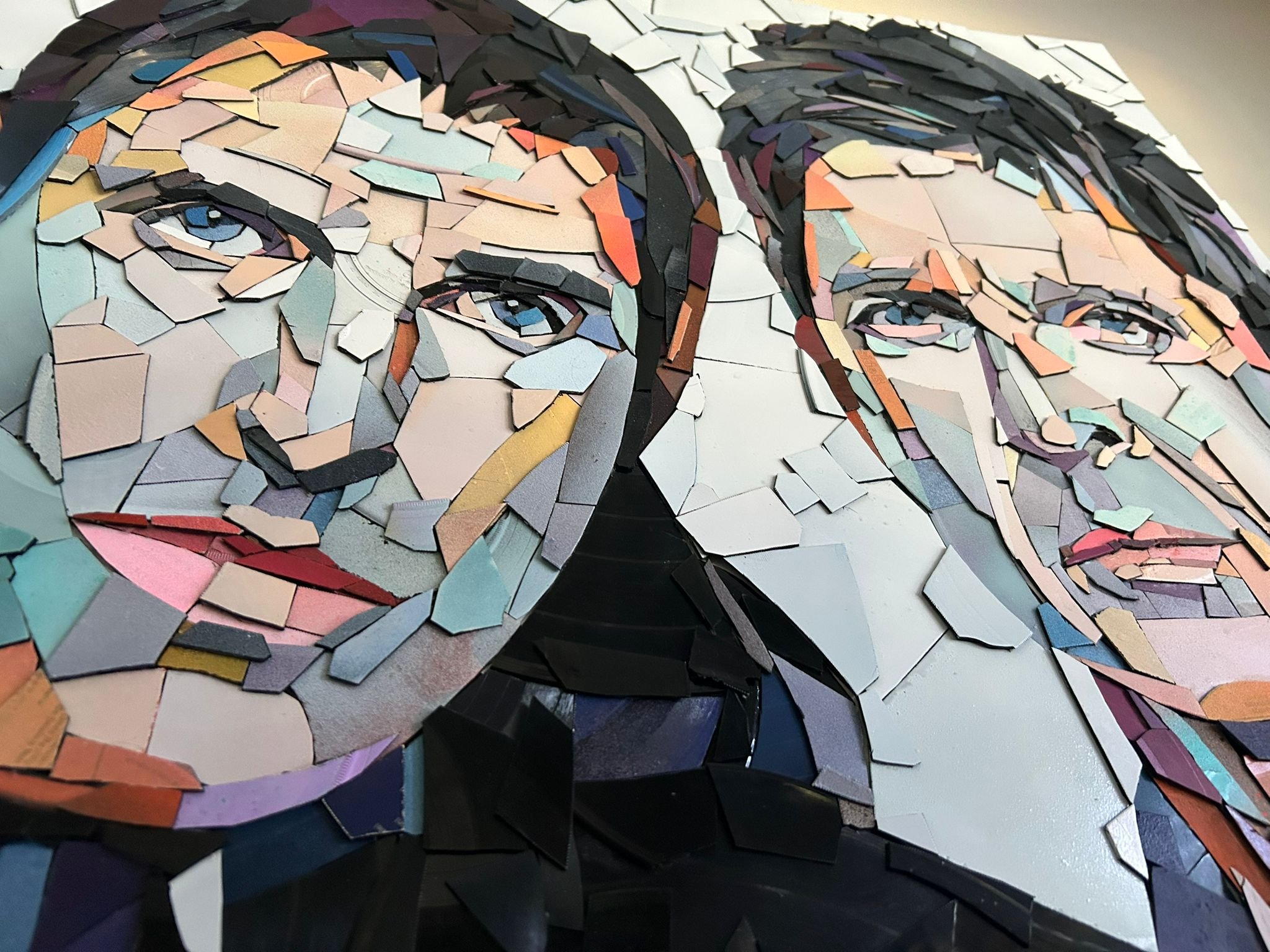 Ed Chapman, The Gallagher Brothers. Made from Hundreds of pieces of. vinyl records. . Individually applied. To produce a portrait of Liam Gallagher and Noel Gallagher. With bright, vibrant colours.