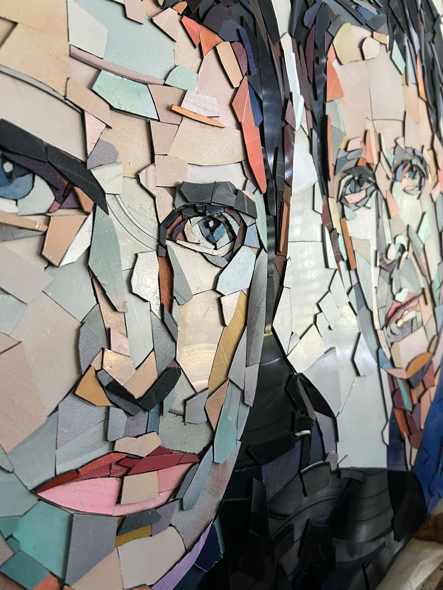 Ed Chapman, The Gallagher Brothers. Made from Hundreds of pieces of. vinyl records. . Individually applied. To produce a portrait of Liam Gallagher and Noel Gallagher. With bright, vibrant colours.