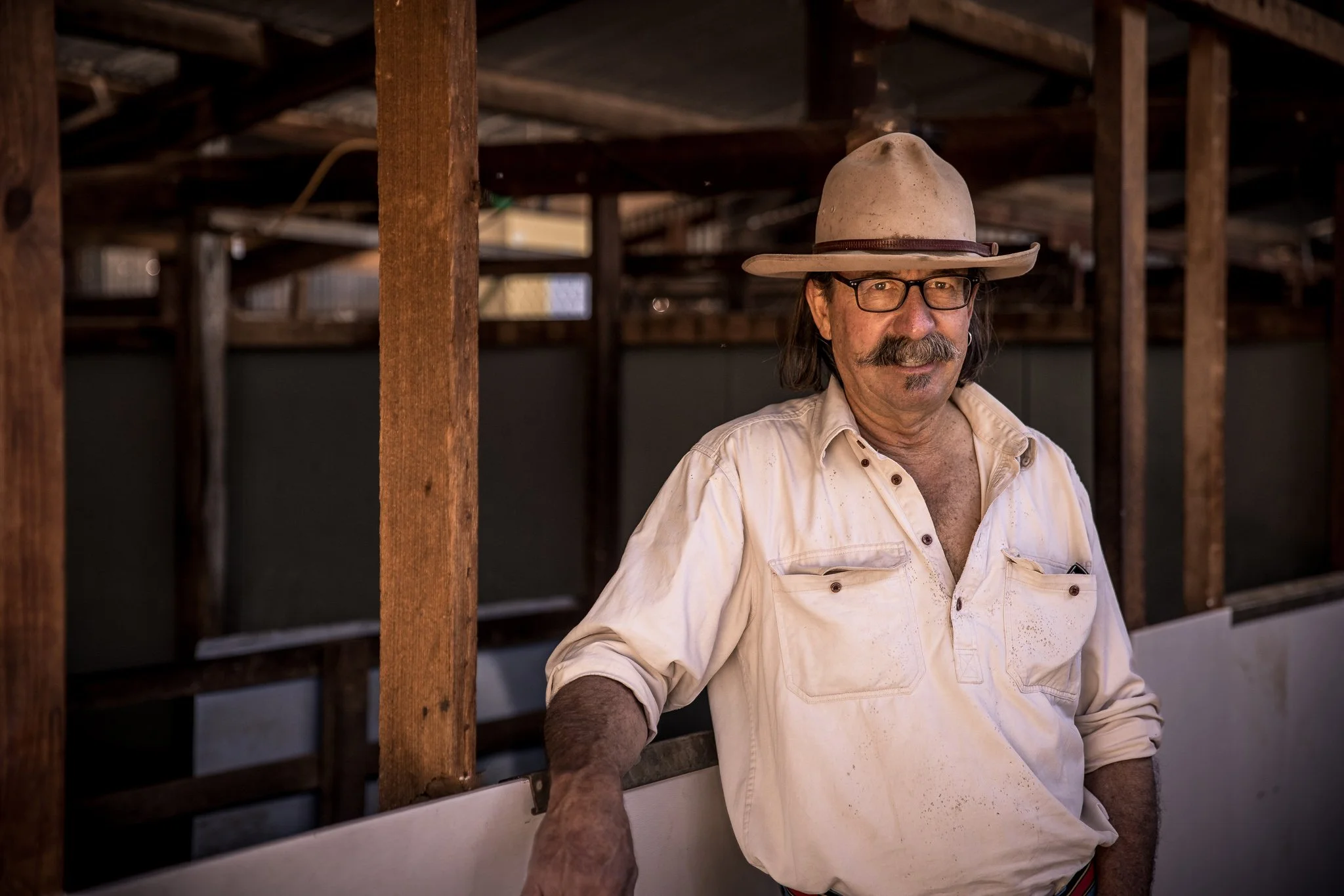 Man wearing a hat and glasses in a rustic building