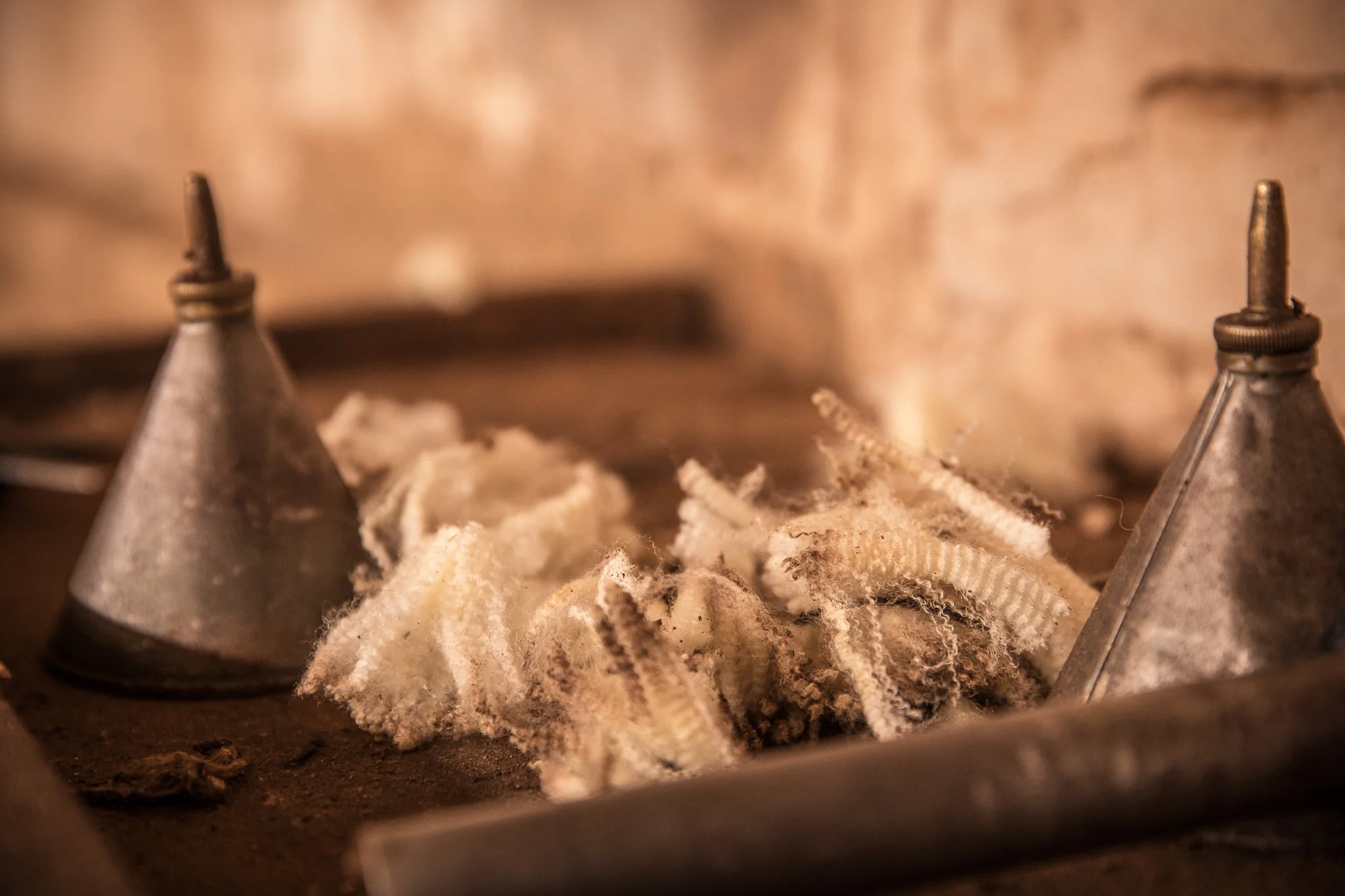 Close-up of an industrial object with metallic funnels and fibrous material