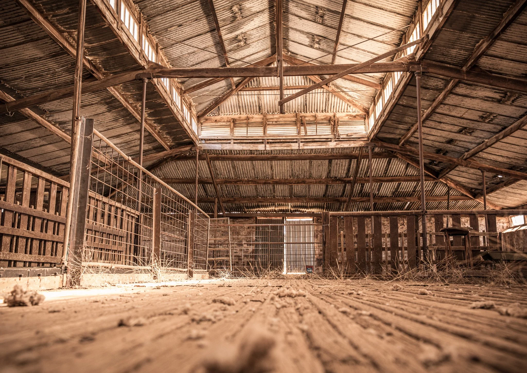 interior of an old abandoned barn with corrugated metal roof and wooden beams