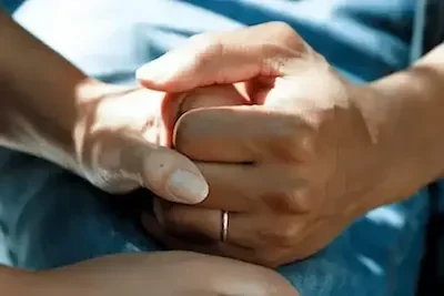 Two persons hands being held, signifying the comfort and support provided during detox & stabilisation