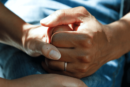 Two hands gently clasped in a moment of quiet connection, symbolising long-term support and emotional healing.