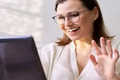 Our friendly Therapist greeting a client during their aftercare program in a meeting on the computer