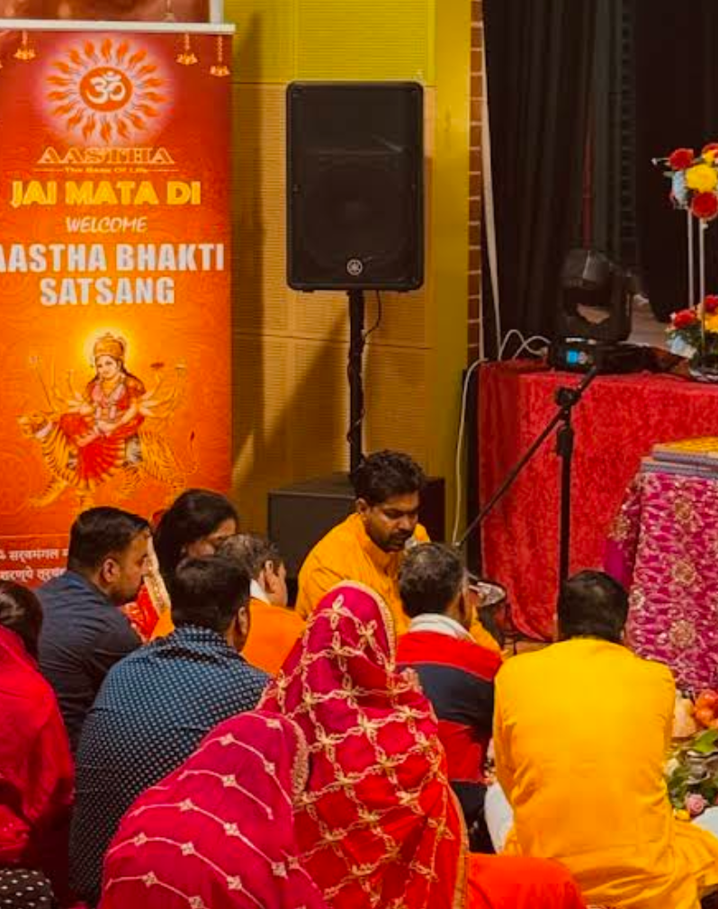 Acharya Raj leading a Hindu jagrata with a large group of devotees in Melbourne, performing kirtan and pooja rituals.