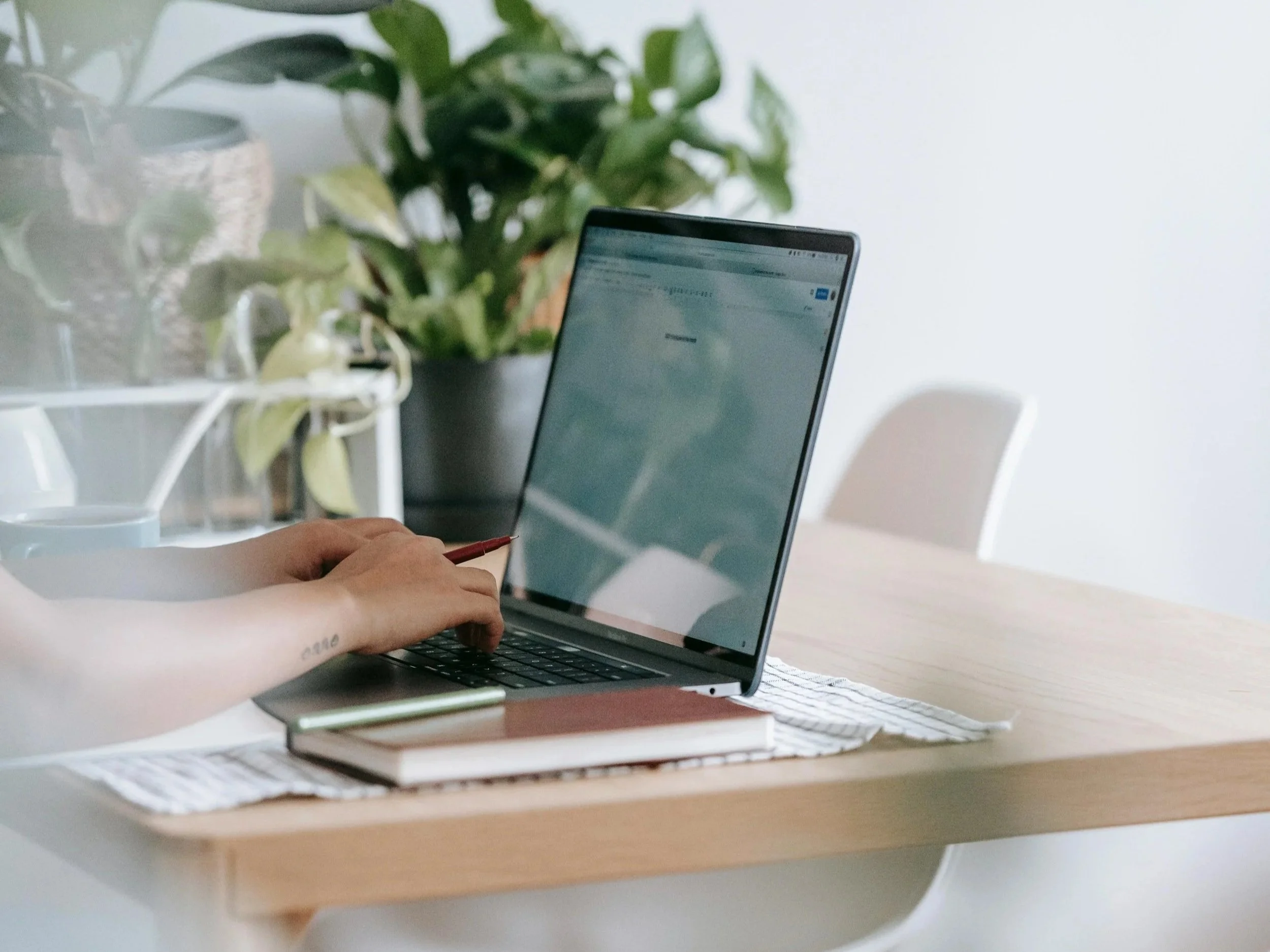 Laptop and notebook in a comfortable workspace, symbolizing in-person or telehealth counseling.