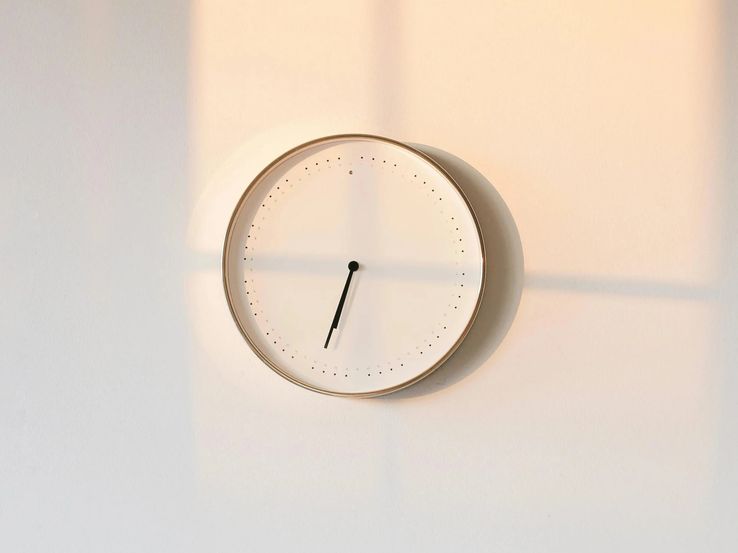 Minimalist clock on a desk, representing coordinated care and thoughtful communication.