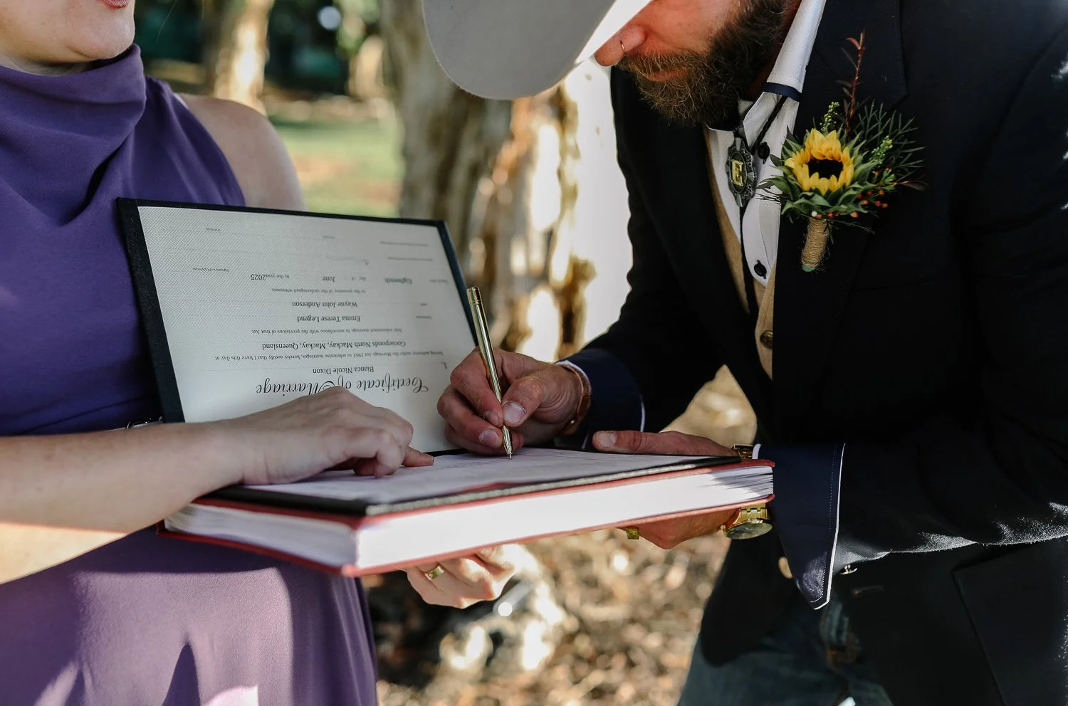 Groom signing legal paperwork after elopement